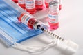 new coronavirus infection vaccine with fill syringe and clean medical mask