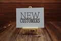 New Customers text on paper card on wooden background Royalty Free Stock Photo