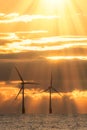 New dawn. Offshore wind turbines silhouetted by beautiful sunrise