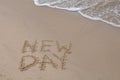 New Day words - drawing on the sand, handwritten on the sea beach sand Royalty Free Stock Photo