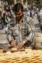 New Dehli, India, Feb 19, 2018: Man prepares pineapple for sale on street cart