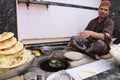 man baking big Tandoori breads in the traditional earth oven during Ramadan. Mughal food