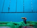 New Delhi, Delhi / India- May 31 2020: A labor working at a construction site wearing a yellow hat, on a blue background