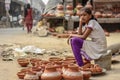 New Delhi, Delhi/ India- May 31 2020: A very young girl selling mud pots, sitting in a hot summer day