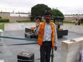 A man shows the palm of his hand next to the Mahatma Gandhi Raj Ghat Memorial