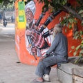 New Delhi, India - December 25, 2021 - Old poor man drinking tea during the winter season in old street of Delhi, Delhi Street