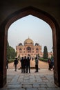 New Delhi, India - December 7, 2019: Tourists take photos of Humayan`s Tomb, photo framed by an arch doorway