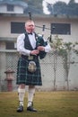 Scottish piper from Scotland in traditional outfit with tartan kilt playing bagpipe Royalty Free Stock Photo