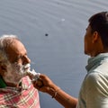 New Delhi, India - March 04, 2020: Handsome old man shaving his beard in bathroom during morning time at Yamuna river ghat in New