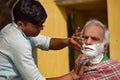 New Delhi, India - March 04, 2020: Handsome old man shaving his beard in bathroom during morning time at Yamuna river ghat in New