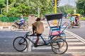 Driver resting on his bicycle rickshaw in New Delhi, India