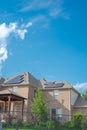 New development two story suburban residential house with metal fence, covered patio and black solar panels on shingle roofing Royalty Free Stock Photo