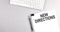 NEW DIRECTIONS text on paper with keyboard on grey background Royalty Free Stock Photo