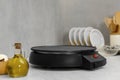 New electrical crepe maker on white marble table in kitchen