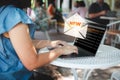 New email notification alert. Woman using laptop receives a new message on email icons in virtual screen at the cafe.