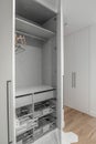 New empty modern closet wardrobe shelves by grey finish material and opened doors. Closet with hangers and rail rack Royalty Free Stock Photo