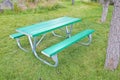 New empty picnic table in galvanized metal tubing and green plastic shelves on a green meadow
