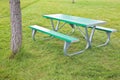 New empty picnic table in galvanized metal tubing and green plastic shelves on a green meadow