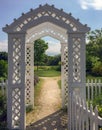 New England white wooden arbor garden gates and sunlit path