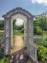 New England white wooden arbor garden gates and sunlit path