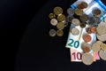 20 and 10 new euro banknote with coins  on black background, top view. Empty space on the left. Royalty Free Stock Photo