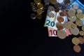 20 and 10 new euro banknote with coins  on black background, top view. Empty space on the left. Royalty Free Stock Photo