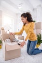 Pleasant curly girl taking lamp out of the box