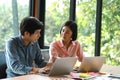 New generation of young men and women are sitting, consulting, working and using laptop on office desk Royalty Free Stock Photo