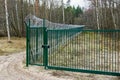 A new green metal mesh fence with coiled barbed wire and gate around the restricted area Royalty Free Stock Photo