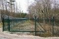 A new green metal mesh fence with coiled barbed wire and gate around the restricted area Royalty Free Stock Photo