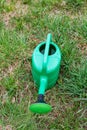 New green watering can standing on grass Royalty Free Stock Photo