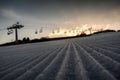 New groomed ski piste or fresh slope. Empty ski-lift at background