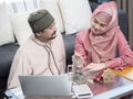 New happy muslim couple looking at each other and putting coins in a jar glass for save their money Royalty Free Stock Photo