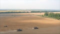 New harvesters on the field collect wheat. Panoramic view on the field of collected wheat. On the background the combine harvester