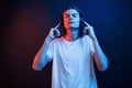 New headphones sounds awesome. Studio shot in dark studio with neon light. Portrait of serious man Royalty Free Stock Photo