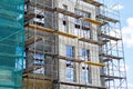 New high-rise building under construction with brick work and wooden scaffolding. Concrete building under construction. Building u Royalty Free Stock Photo