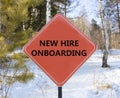 New hire onboarding symbol. Concept words New hire onboarding on beautiful red road sign. Beautiful forest snow blue sky Royalty Free Stock Photo