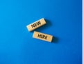 New hire symbol. Wooden blocks with words New hire. Beautiful blue background. Business and New hire concept. Copy space Royalty Free Stock Photo