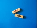 New hire symbol. Wooden blocks with words New hire. Beautiful blue background. Business and New hire concept. Copy space Royalty Free Stock Photo