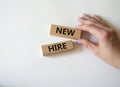 New hire symbol. Wooden blocks with words New hire. Beautiful white background. Businessman hand. Business and New hire concept. Royalty Free Stock Photo