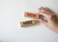 New hire symbol. Wooden blocks with words New hire. Beautiful white background. Businessman hand. Business and New hire concept. Royalty Free Stock Photo