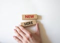 New hire symbol. Wooden blocks with words New hire. Beautiful white background. Businessman hand. Business and New hire concept. Royalty Free Stock Photo