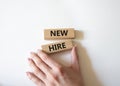 New hire symbol. Wooden blocks with words New hire. Beautiful white background. Businessman hand. Business and New hire concept. Royalty Free Stock Photo