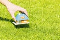 New home concept, hand putting house scale model on grass