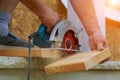 Building contractor worker using hand held worm drive circular saw to cut boards on a new home constructiion project Royalty Free Stock Photo