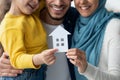 New Home. Happy muslim family holding cutout paper house figure in hands Royalty Free Stock Photo