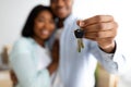 New home owners. Happy african american couple holding home keys, celebrating buying new flat, selective focus Royalty Free Stock Photo