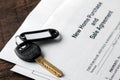 New home purchase and sale agreement. Key with keyring and blank on a brown wooden table. concept of buying a home Royalty Free Stock Photo