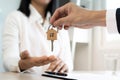 A new homeowner accepts a house key from a real estate agent after agreeing to a successful buy-home purchase-sale contract. House Royalty Free Stock Photo