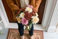 new homeowner with a bouquet of chrysanthemums on a monogrammed mat